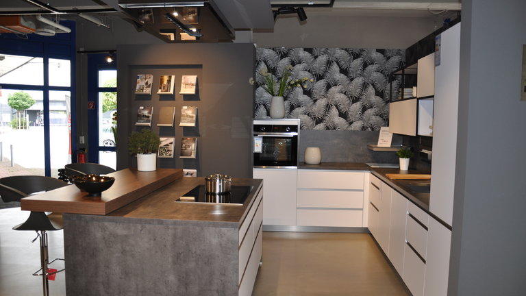 Moderne Häcker Systemat Küche mit polarweißen Mattlackfronten und einer Schichtstoff Arbeitsplatte.